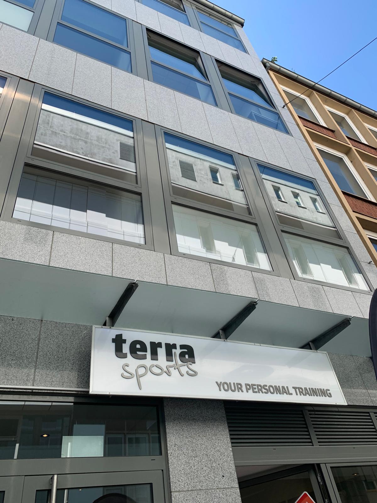 Fassade eines modernen Gebäudes mit einem Sportstudio-Schild.