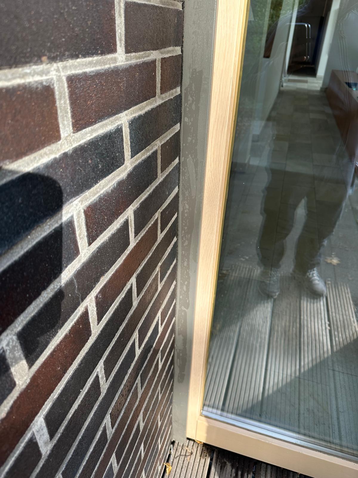 Nahaufnahme einer Wand mit Fenster und Holzrahmen.