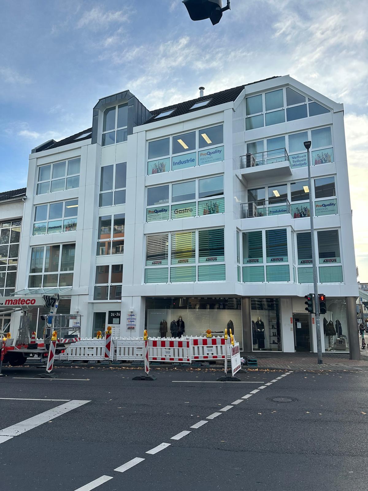 Moderne Geschäftsgebäude mit Schaufenstern und Baustellenabsperrung.