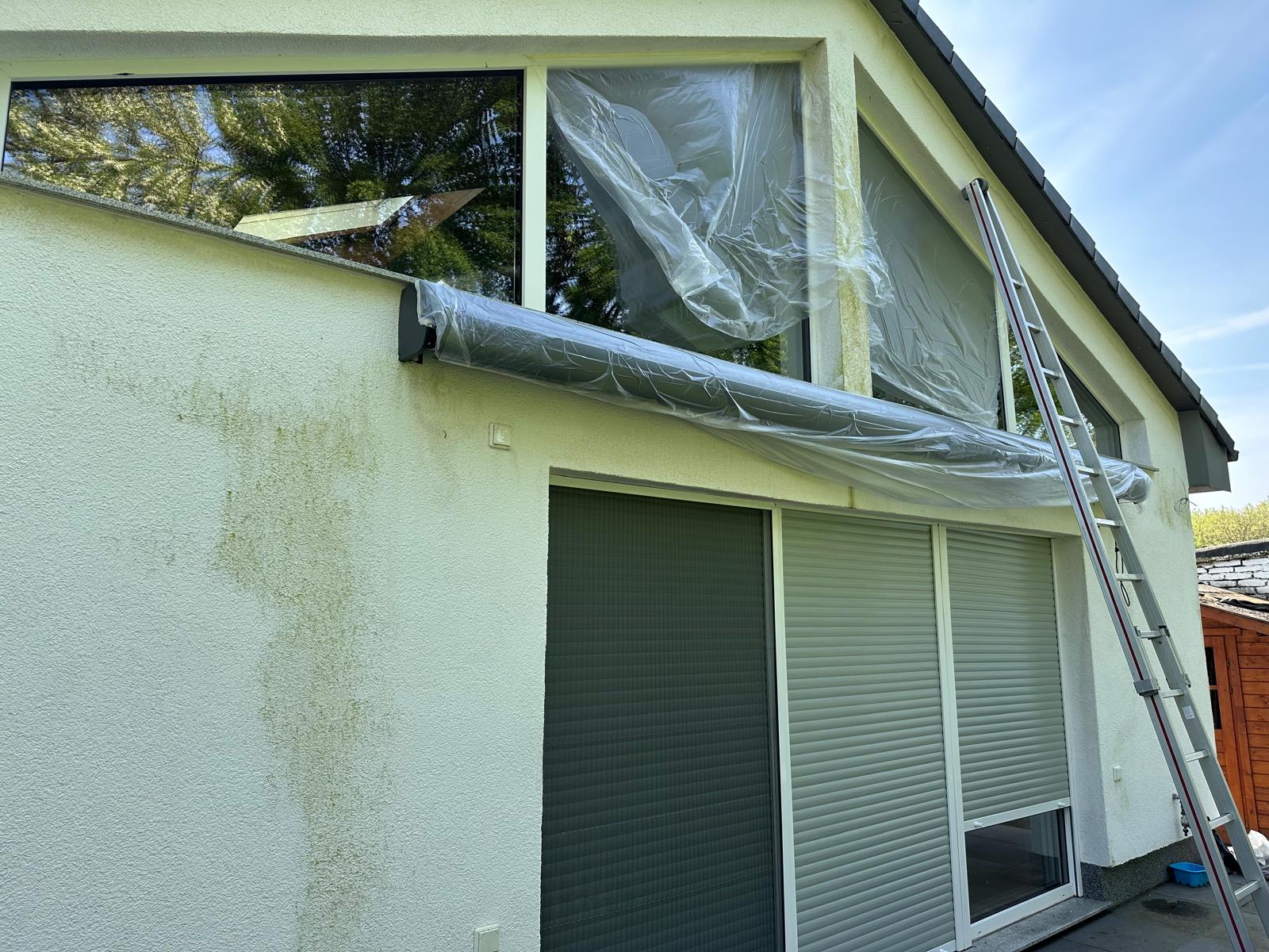 Haus mit Leiter und abgedeckten Fenstern zur Renovierung.