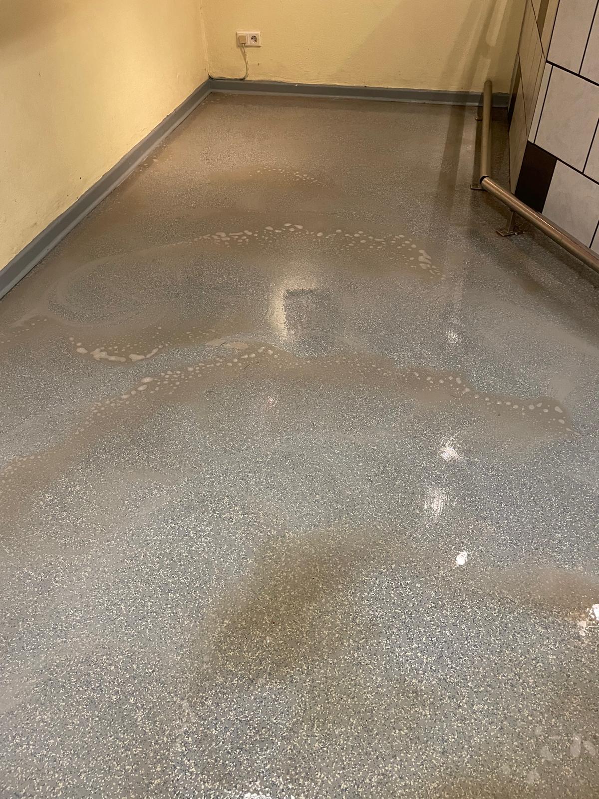 Nasser Boden mit Flecken in einem Raum.