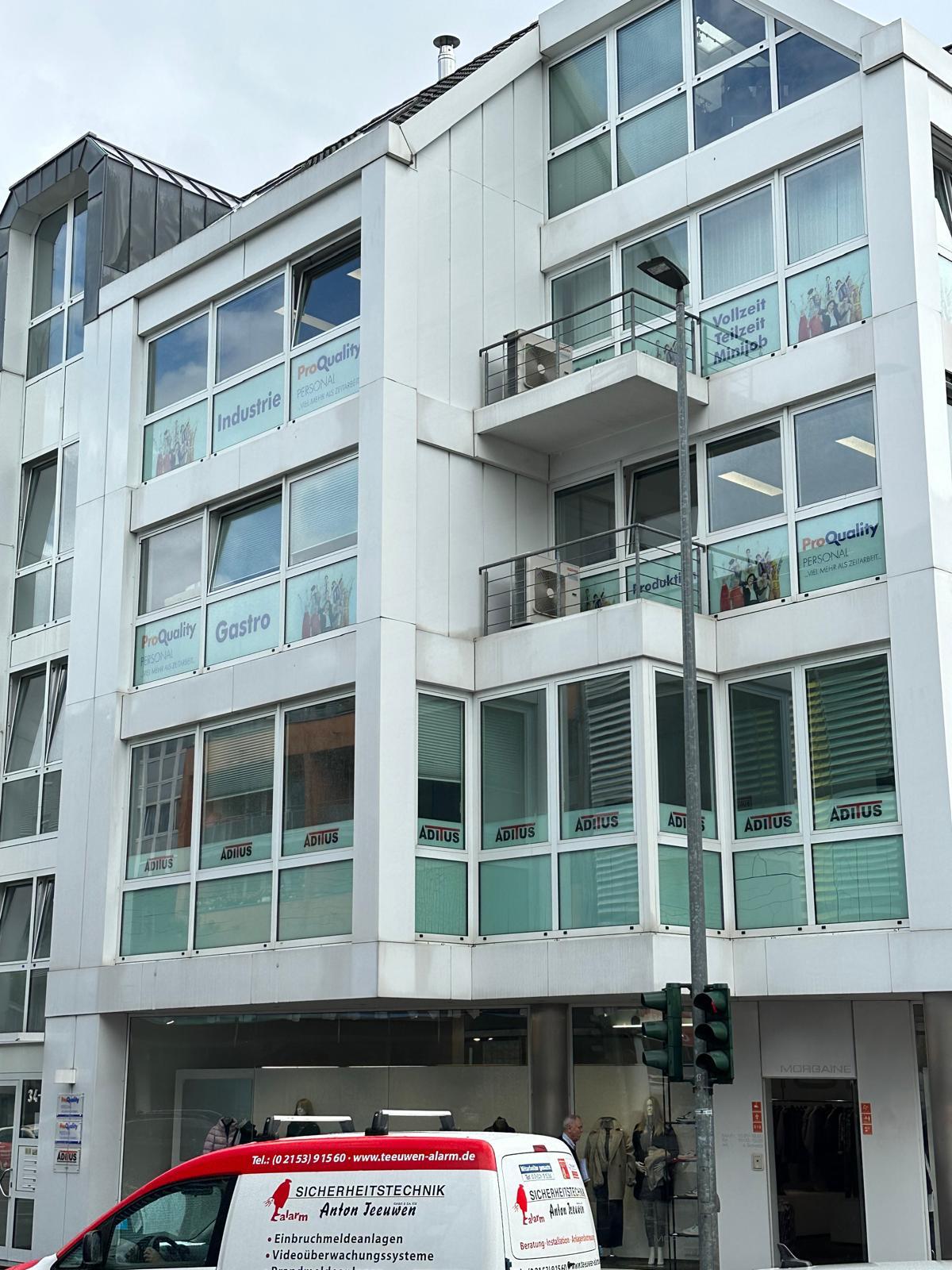 Moderne Bürogebäude mit großen Fenstern und Werbeplakaten.